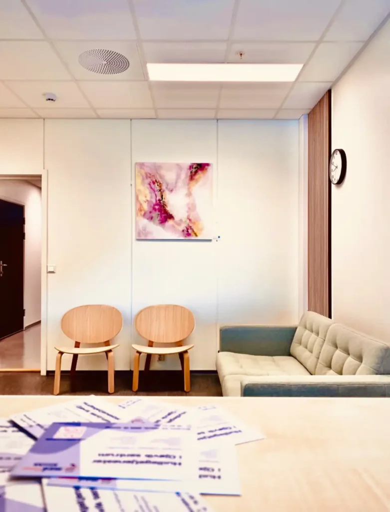 venterom med fargerike maleri og sofa med to stoler